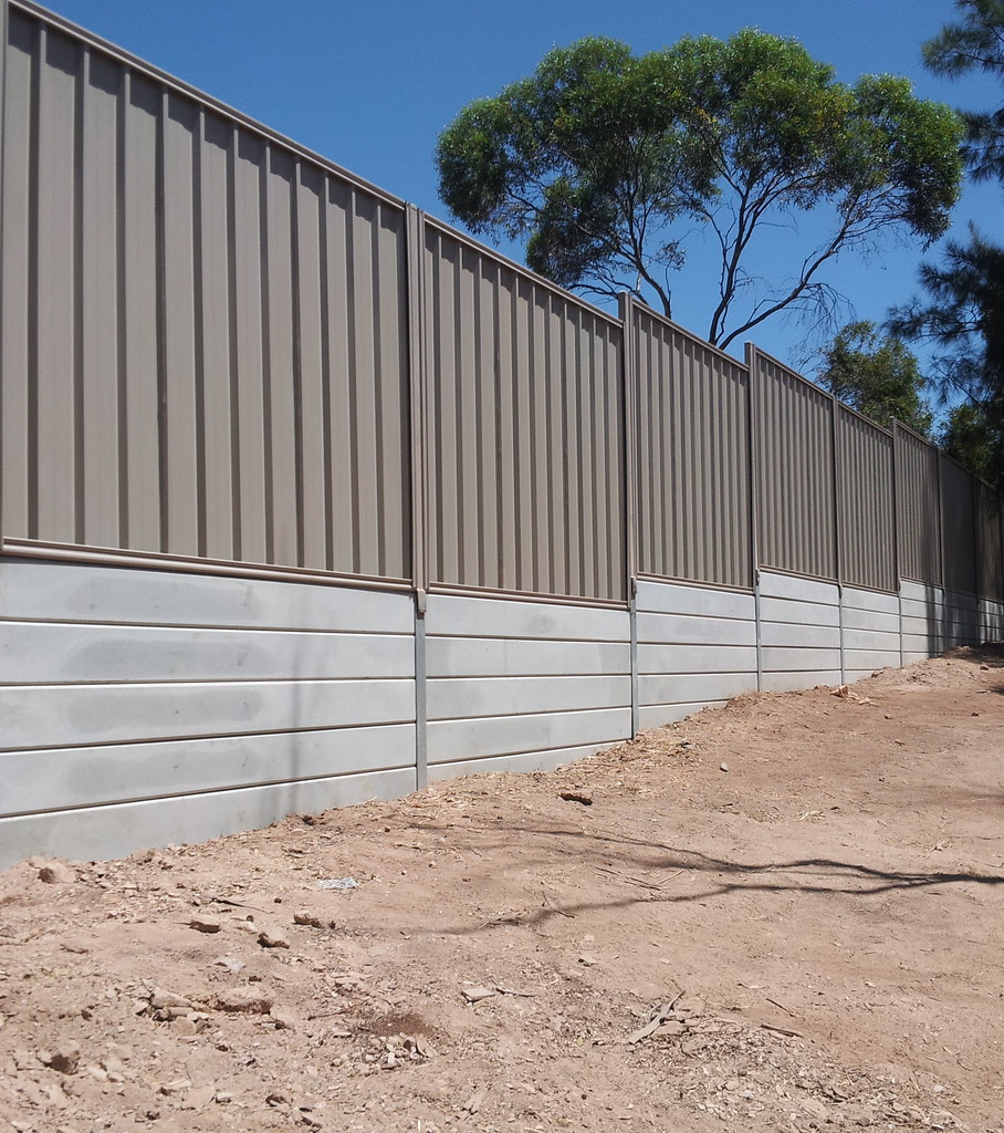 Beige colorbond fencing on retaining wall
